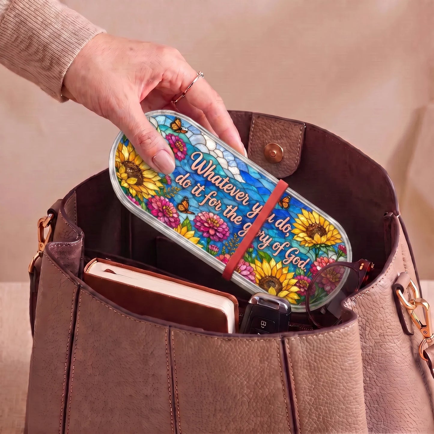 Whatever You Do for the Glory of God Pillcase carried inside a handbag with everyday essentials
