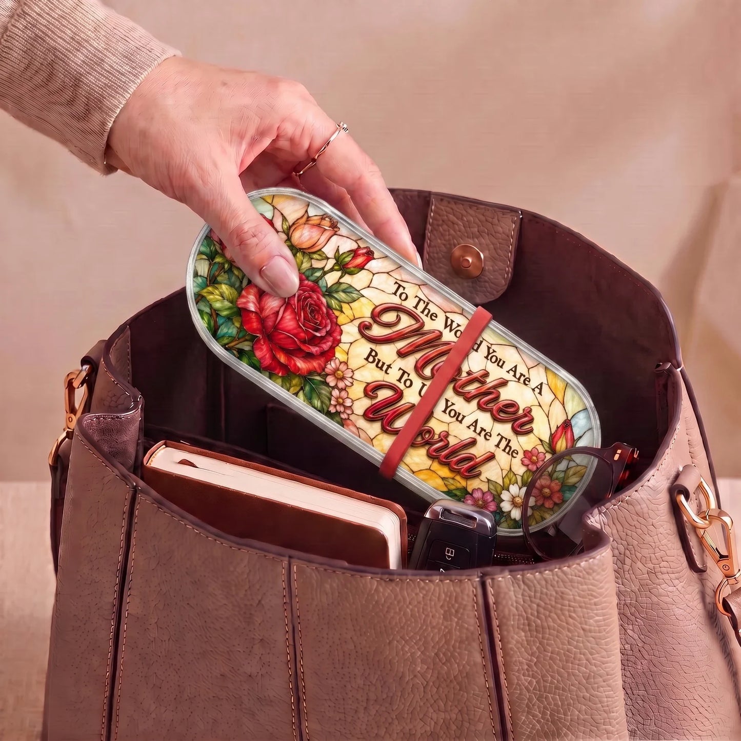 To the World You Are a Mother rose Pillcase carried inside a handbag with everyday essentials