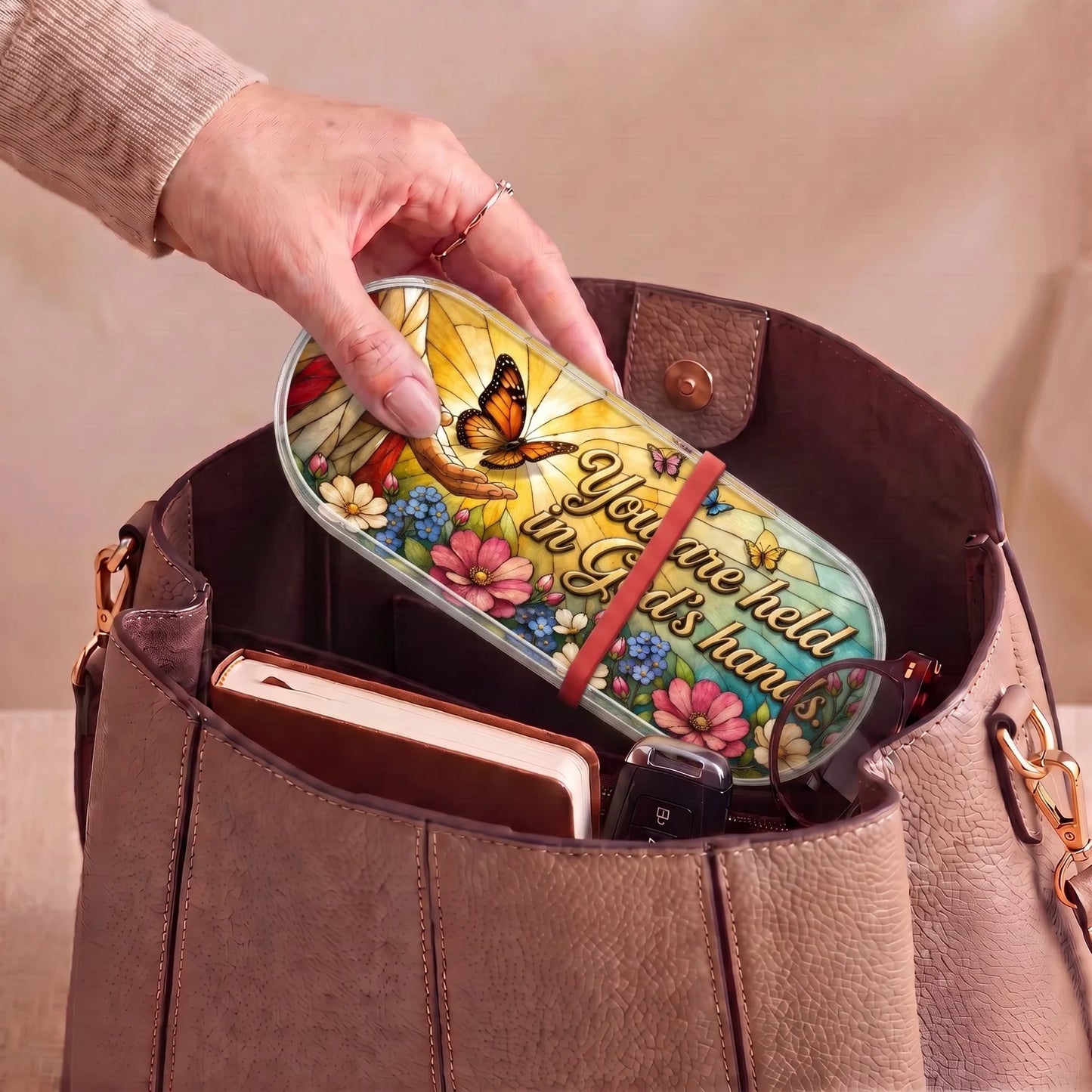 You Are Held in God’s Hands butterfly Pillcase carried inside a handbag with everyday essentials