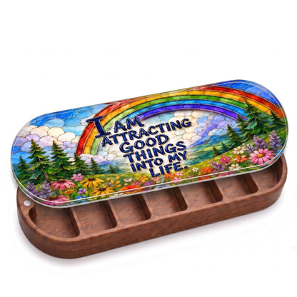 Open wooden Pillcase with rainbow, evergreen forest and wildflower meadow affirmation lid on white