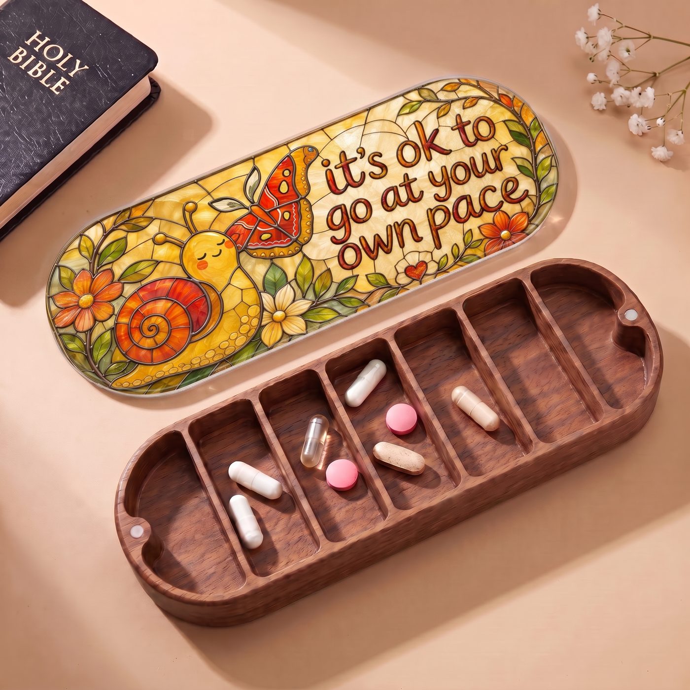 "It’s OK to Go at Your Own Pace — Snail & Butterfly Stained Glass" Pill Case — open Pill Case with Holy Bible, flowers, and assorted pills
