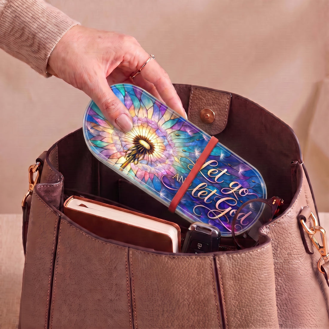 Let Go and Let God dandelion Pillcase carried inside a handbag with everyday essentials