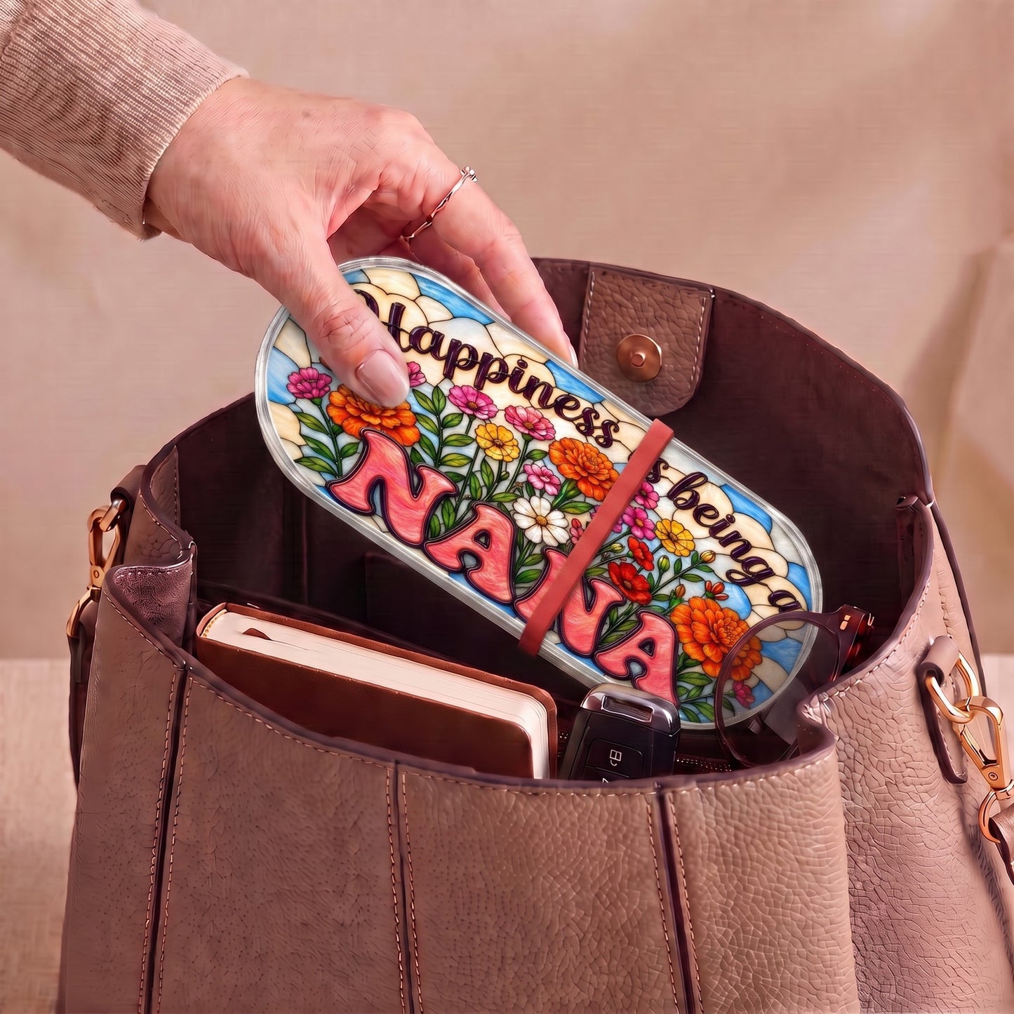 Happiness Is Being a Nana floral Pillcase carried inside a handbag with everyday essentials