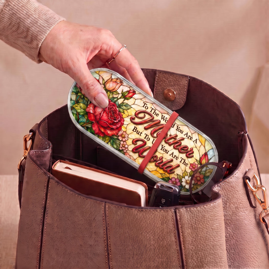 To the World You Are a Mother rose Pillcase carried inside a handbag with everyday essentials