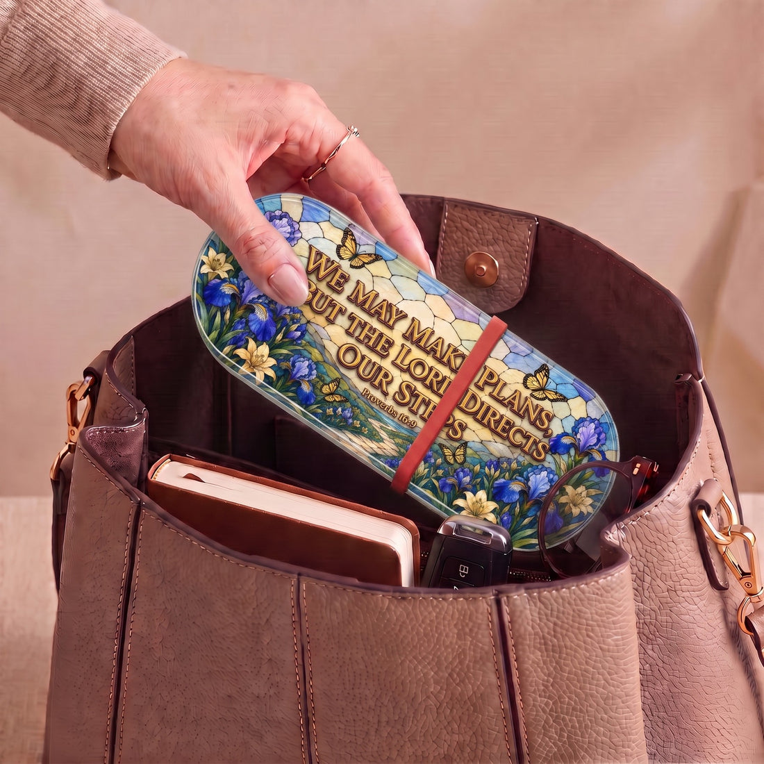 Proverbs 16:9 floral Pillcase carried inside a handbag with everyday essentials