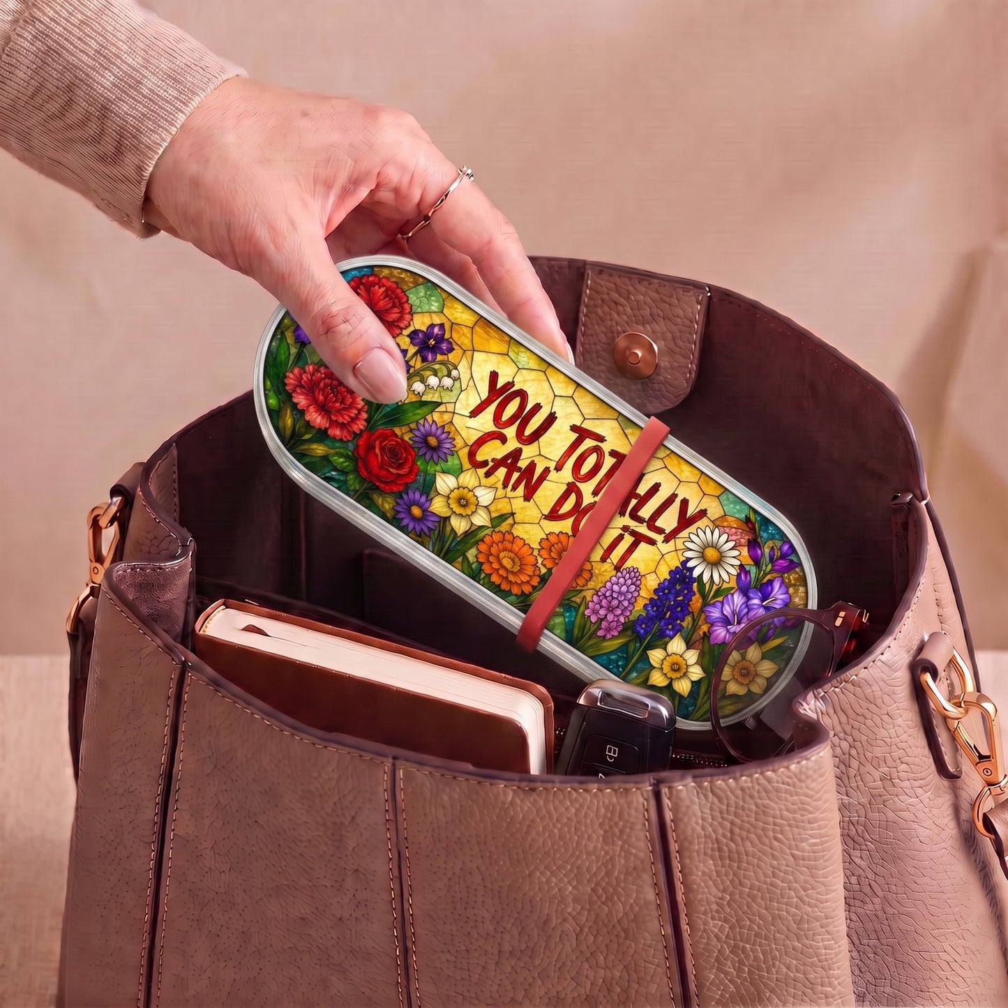 You Totally Can Do It floral Pillcase carried inside a handbag with everyday essentials