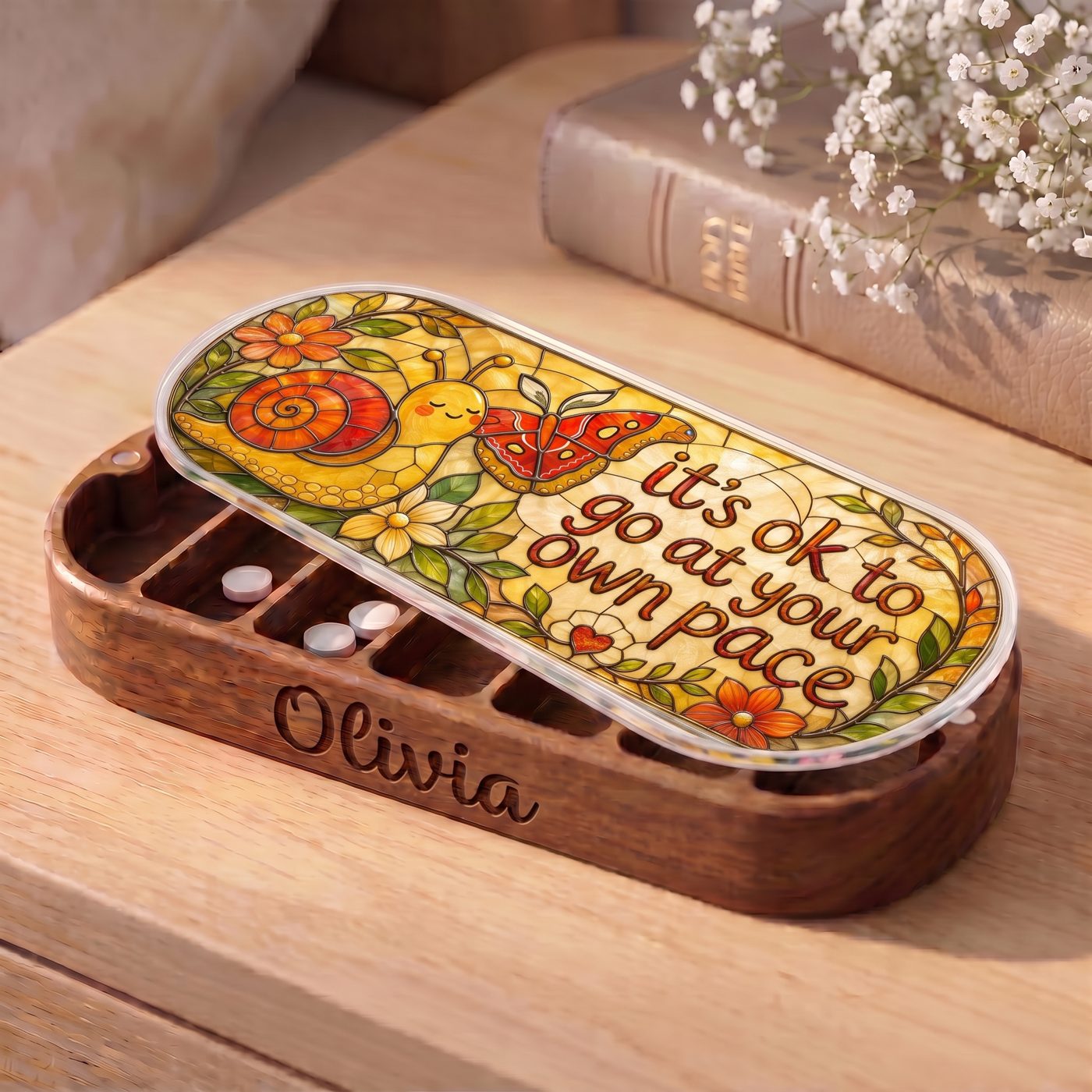 "It’s OK to Go at Your Own Pace — Snail & Butterfly Stained Glass" Pill Case — personalized open snail and butterfly Pill Case on a wooden table