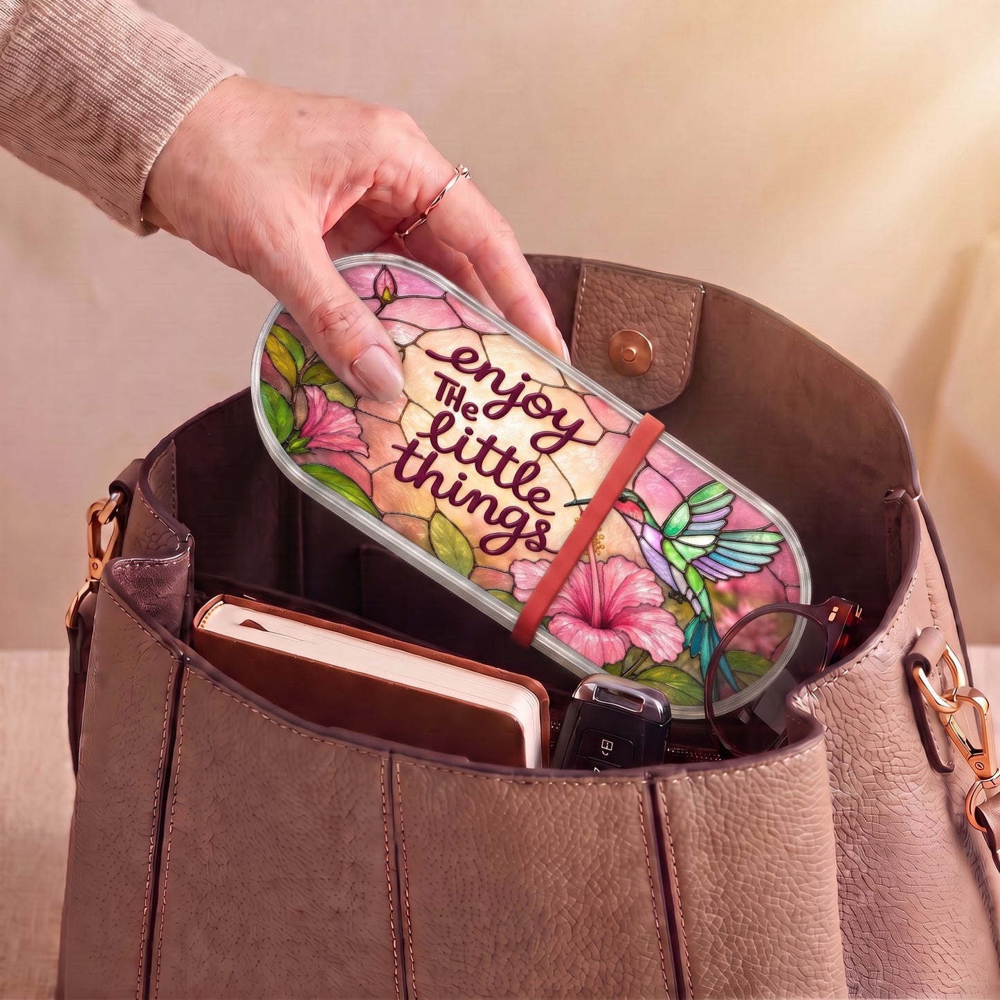 Enjoy the Little Things hummingbird and pink hibiscus Pillcase carried inside a handbag with everyday essentials
